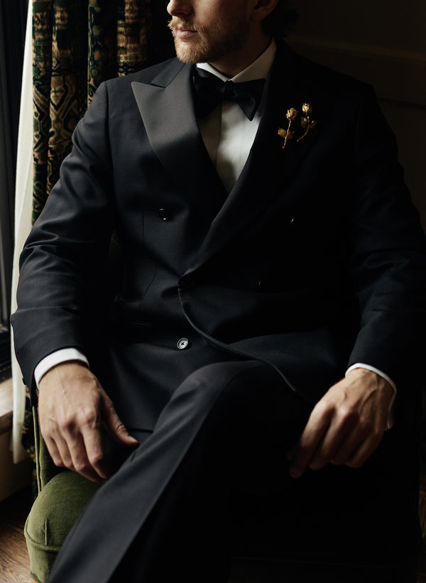 A man is sitting in a tuxedo.
