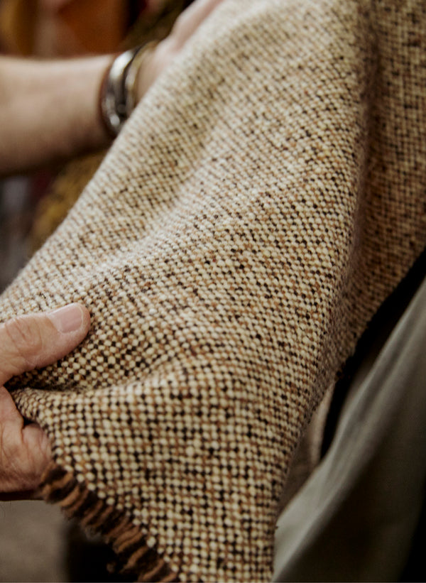 A detailed close-up of high quality fabric being inspected by an artisan.